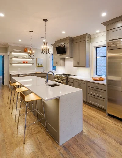 Open concept kitchen remodel in Chicago featuring white cabinets and island seating."
