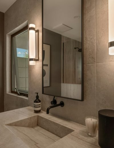 An elevated Palm Springs bathroom remodel blending natural stone, warm wood cabinetry, and spa-inspired lighting. Shot for an architectural designer to showcase luxury renovation details.